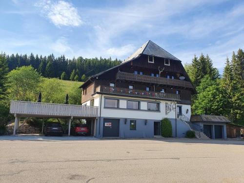 a large building with a gambrel roof and a parking lot at Rinken 9 in Hinterzarten