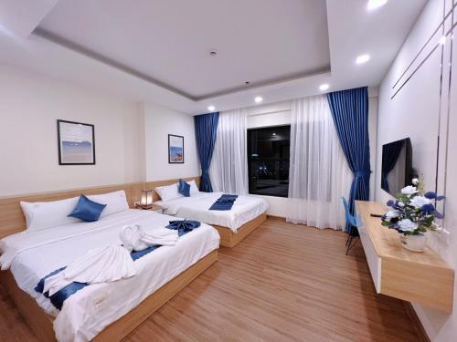 Cette chambre comprend deux lits et une télévision. dans l'établissement FLC Sea Tower Quy Nhơn - Căn Hộ Du Lịch Chuẩn 5 Sao - View Biển có Hồ Bơi, à Quy Nhơn