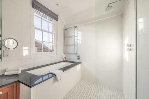 een witte badkamer met een bad en een raam bij Impressive 3 Bed 2 Bath Townhouse in Windsor in Windsor