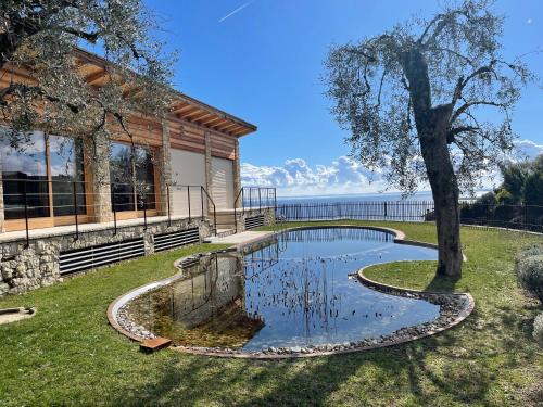 a pool in the yard of a house with a tree at Villa in Gardone Riviera zu vermieten in Gardone Riviera
