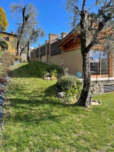 a house with trees in front of a yard at Villa in Gardone Riviera zu vermieten in Gardone Riviera
