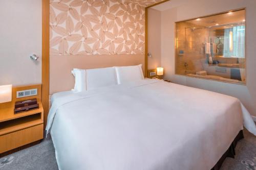 a bedroom with a large white bed and a window at China Mayors Plaza - Free shuttle between hotel and Exhibition Center during Canton Fair in Guangzhou