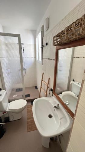 a bathroom with a sink and a toilet and a mirror at Keur Ama in Mbour