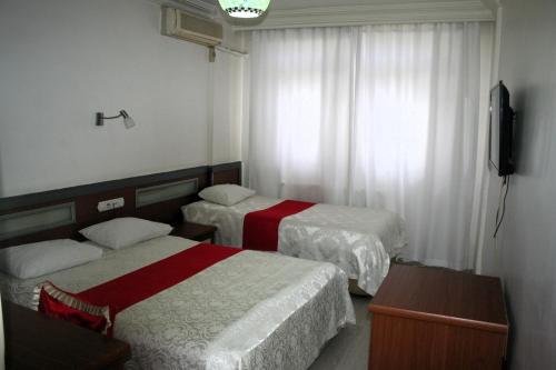 a hotel room with two beds and a television at Yeni Kosk Esra Hotel in Konya