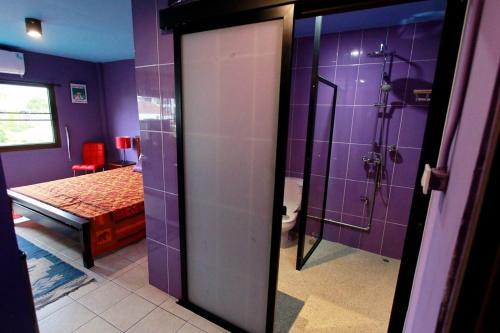 a purple bathroom with a shower and a bed at Chez Pom in Chiang Mai