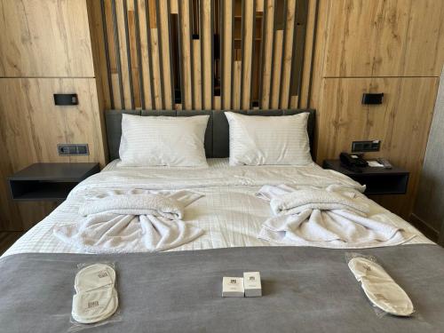 a bed with two pairs of shoes sitting on it at world say hotel in Bostaniçi