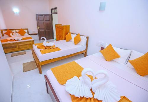 Ella Sriya Holiday Resort في إيلا: وجود بجعتين على سريرين في غرفة
