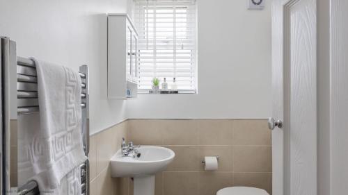 a white bathroom with a sink and a toilet at Coastal Escape close to North Bay- Pet Friendly in Scarborough