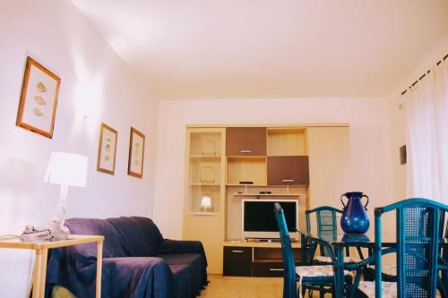 Una sala de estar con un sofá y un televisor. en Rilassante Villetta Marittima, en Stintino