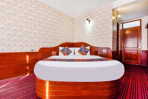 1 dormitorio con 1 cama grande y cabecero de madera en FabHotel Himalyan Valley Resorts, en Manali