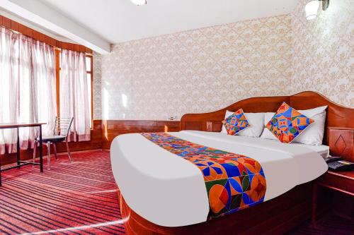 Habitación de hotel con cama, escritorio y mesa. en FabHotel Himalyan Valley Resorts, en Manali