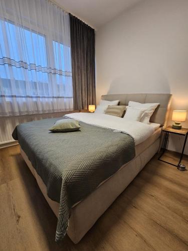 a bedroom with a large bed with a large window at Stadtoase Wels in Wels