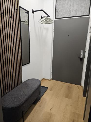 Zimmer mit einem Stuhl und einem Spiegel an der Wand in der Unterkunft Stadtoase Wels in Wels