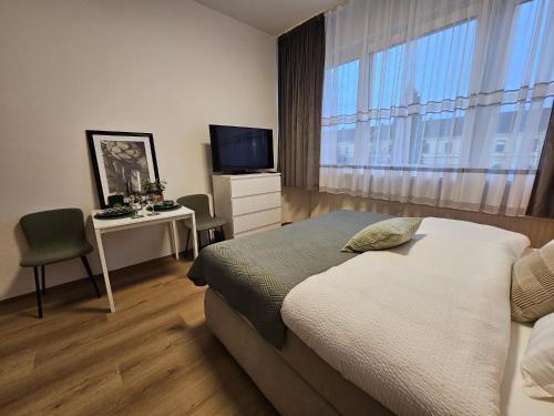 een slaapkamer met een bed, een bureau en een televisie bij Stadtoase Wels in Wels