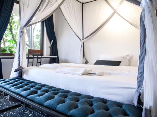 una camera con letto e panca blu di Explorers Hub a Kampala