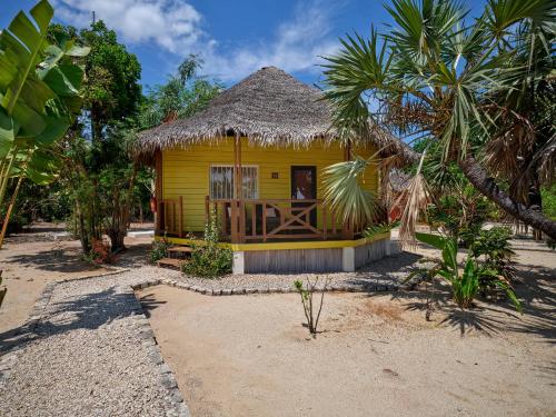 a small yellow house with a thatched roof at Antsanitia Resort in Mahajanga