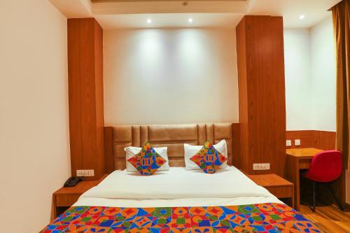 a bedroom with a bed with two pillows on it at FabHotel Prime Swarn Bhoomi in Kānpur