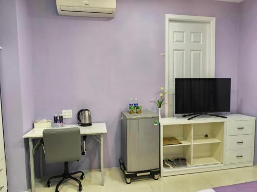a room with a desk and a tv and a desk with a chair at HT Hotel Apartment in Ho Chi Minh City