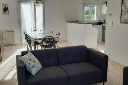 un salon avec un canapé bleu et une table dans l'établissement La Maison Enzo, à Arrest