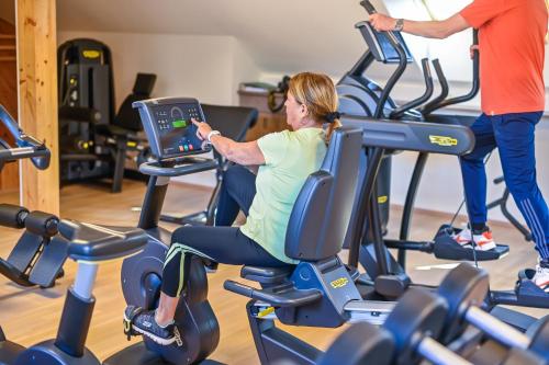 a woman riding on an exercise bike in a gym at Genuss-Pension Herti in Übelbach