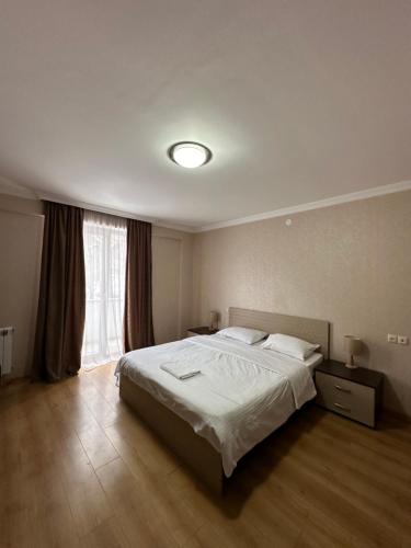 a bedroom with a bed and a large window at Bakuriani Orbi Palace in Bakuriani