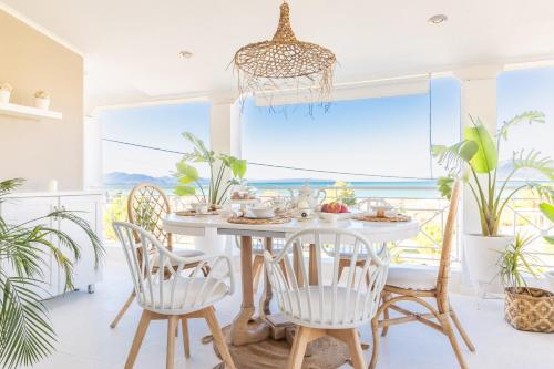a dining room with a table and chairs with a view of the ocean at Mary's Villa in Néa Artáki
