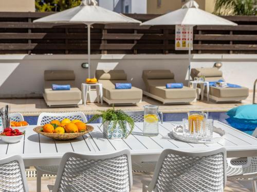 une table blanche avec un bol de fruits dessus dans l'établissement Villa Eftihia, à Protaras