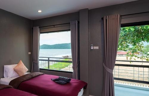 a bedroom with a bed and a window with a view at Kodtalay Resort in Chao Lao Beach