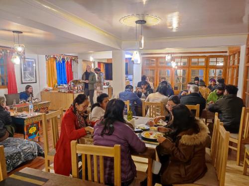 a group of people sitting at tables in a restaurant at Snow Lion Ladakh in Leh