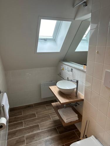 a bathroom with a sink and a skylight at Hotel Auri in Rudník