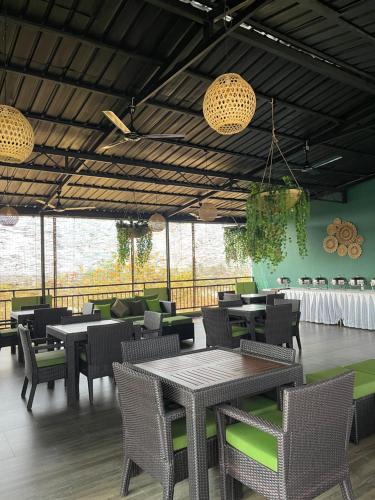 un comedor con mesas, sillas y ventanas en Grand Rovinka Hotel en Dehiwala