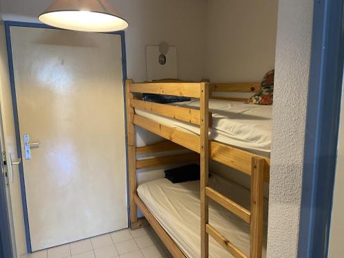 Cette chambre dispose de lits superposés avec 2 lits superposés et une porte. dans l'établissement Sol-y-Days Flamants roses, appartement rez-de-jardin avec piscine, à La Grande Motte