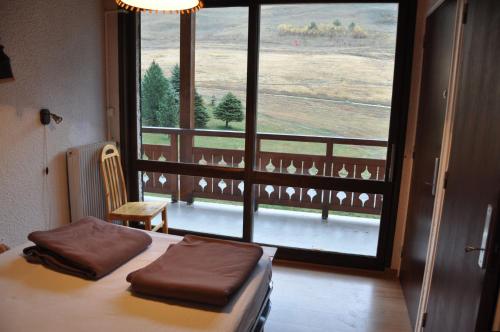 een slaapkamer met een bed en een groot raam bij Eperon 3 - 11 - Appart proche piste - 6 pers in Les Deux Alpes