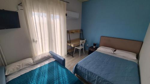 a small room with two beds and a window at ΛΙΜΑΝΙ in Chios