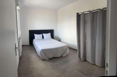 une chambre avec un lit et un rideau de douche dans l'établissement Très beau T2, à Ajaccio