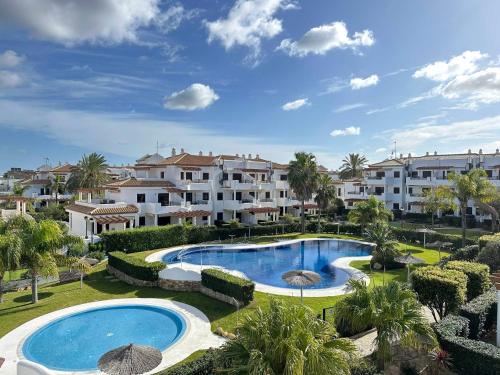 Una vista de una piscina en un resort. en Coto de Sancti Petri, en Chiclana de la Frontera