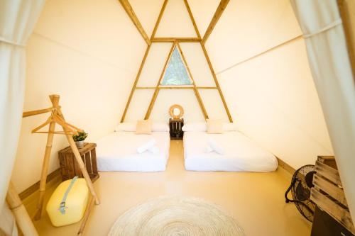Duas camas num quarto com uma janela em Kampaoh Ruiloba em Liandres
