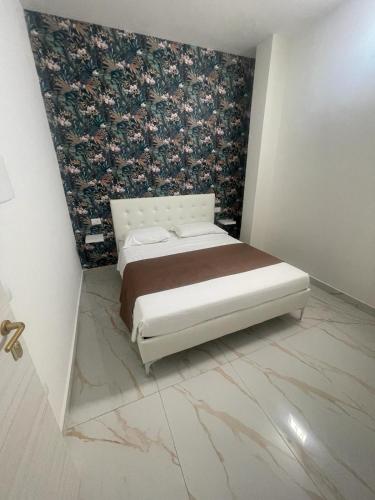 a bedroom with a bed with a floral wallpaper at Life Hotel in Casalnuovo di Napoli