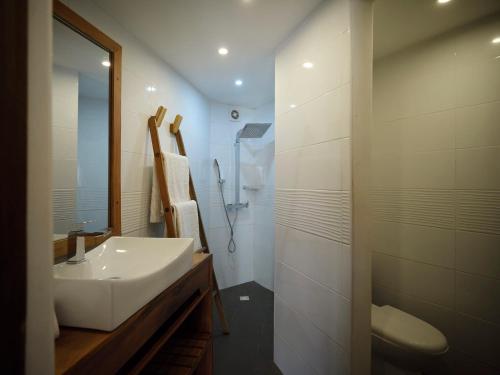 a white bathroom with a sink and a shower at Antsanitia Resort in Mahajanga