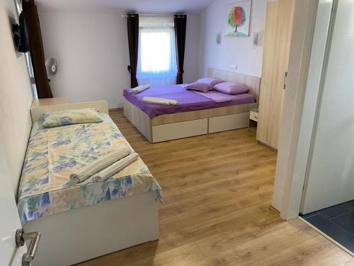 ヴーシにあるApartmani FILTEAの紫のシーツが備わる客室内のベッド2台