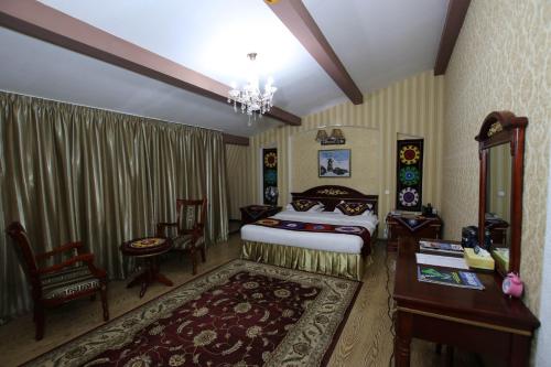a bedroom with a bed and a desk and a table at ORIYO DUSHANBE HOTEL in Dushanbe