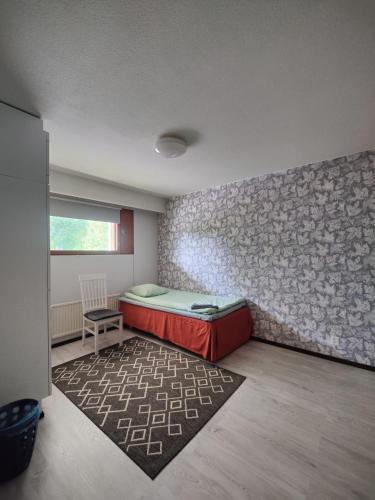 Habitación con cama, alfombra y pared en Ketola Apartments Reisjärvi, en Reisjärvi
