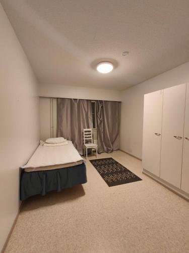 1 dormitorio con 1 cama y 1 silla en Ketola Apartments Reisjärvi, en Reisjärvi
