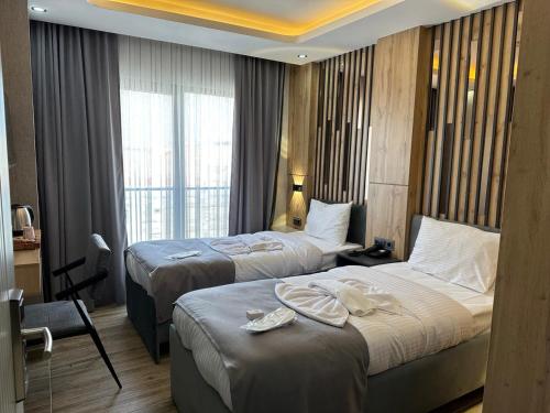 a hotel room with two beds and a window at world say hotel in Bostaniçi
