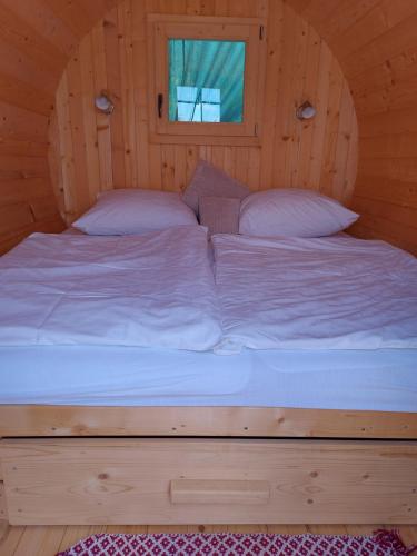 a large bed in a wooden room at MANÓ HORDÓHÁZAK in Pázmánd