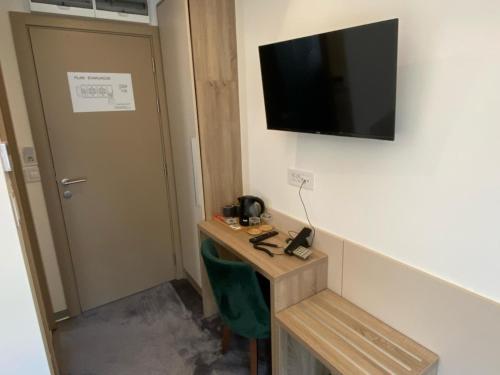 a room with a desk and a television on the wall at Konak Stella in Belgrade