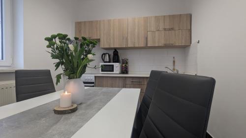 a kitchen with a table with a candle and flowers at Penzion Janoušek Motorsport Český Krumlov in Přísečná