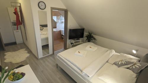 Habitación pequeña con cama y espejo. en Penzion Janoušek Motorsport Český Krumlov en Přísečná
