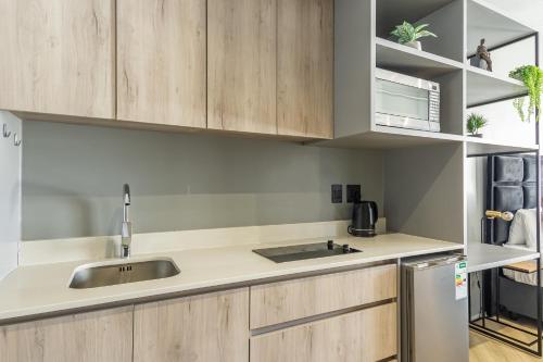 a kitchen with wooden cabinets and a sink at Smart, Contemporary Designed Apartment in Cape Town