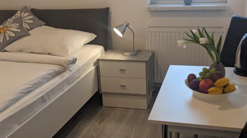 a bedroom with a bed and a table with a bowl of fruit at Penzion Janoušek Motorsport Český Krumlov in Přísečná